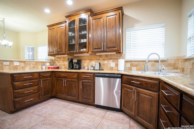 kitchen featuring tasteful backsplash, glass insert cabinets, dishwasher, a peninsula, and a sink