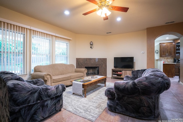 living room with recessed lighting, visible vents, arched walkways, and a premium fireplace