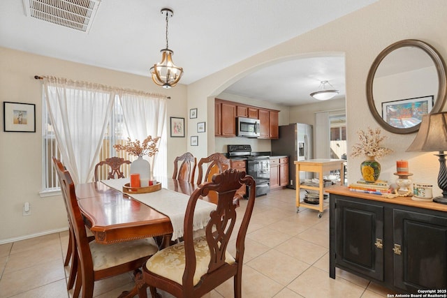 dining space with a notable chandelier, arched walkways, visible vents, and light tile patterned floors