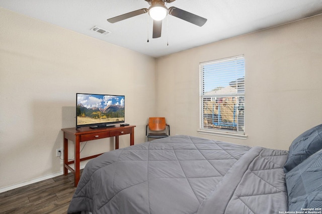 bedroom featuring a ceiling fan, wood finished floors, visible vents, and baseboards