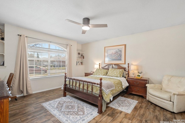 bedroom featuring baseboards, a textured ceiling, a ceiling fan, and wood finished floors