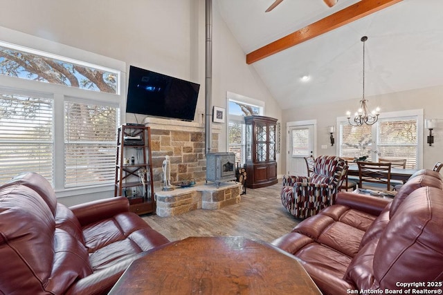 living area featuring wood finished floors, high vaulted ceiling, a wood stove, beamed ceiling, and a notable chandelier