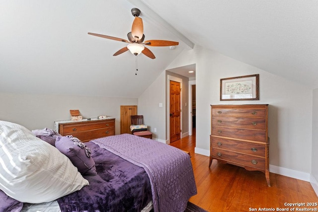 bedroom featuring a ceiling fan, lofted ceiling with beams, wood finished floors, and baseboards