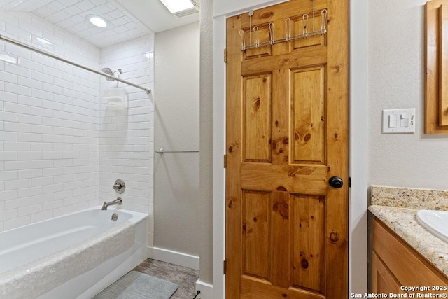 bathroom with vanity, shower / bath combination, and baseboards