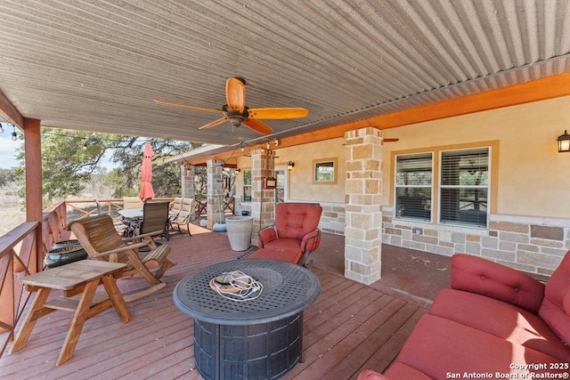 wooden deck with outdoor dining space and a ceiling fan