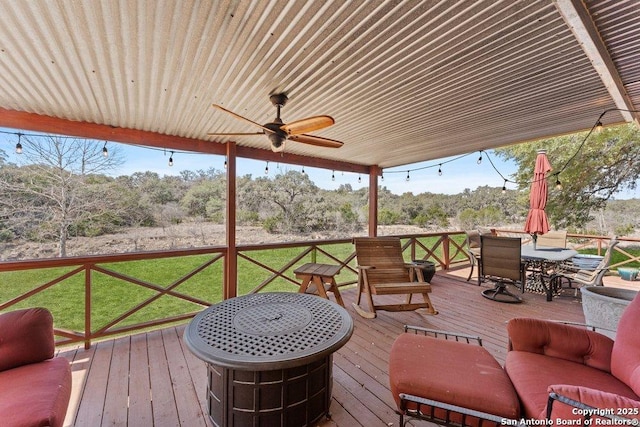 wooden deck featuring a yard, outdoor dining area, and ceiling fan