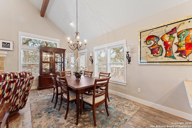 dining room with a wealth of natural light, baseboards, beam ceiling, and a chandelier