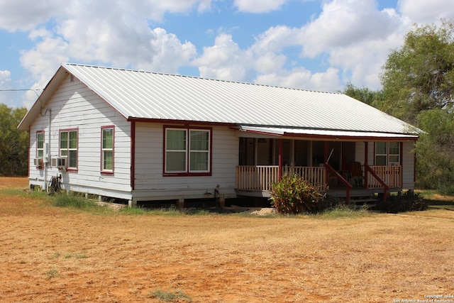 rear view of property featuring metal roof and covered porch