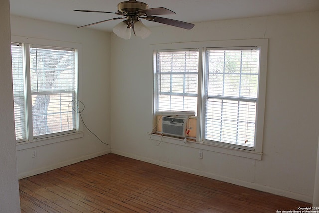 unfurnished room featuring cooling unit, plenty of natural light, wood-type flooring, and a ceiling fan