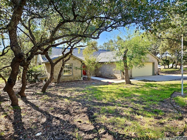 view of front of home featuring a garage, stone siding, and concrete driveway