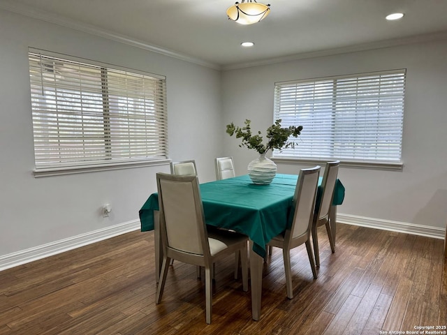 dining area featuring dark wood-type flooring, baseboards, and ornamental molding