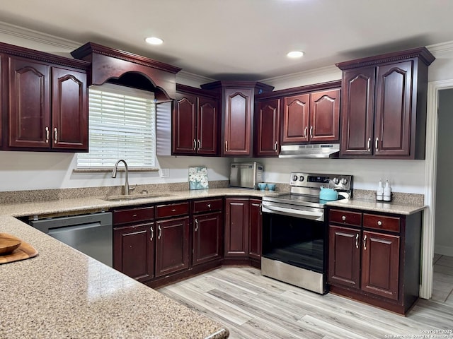 kitchen featuring under cabinet range hood, reddish brown cabinets, appliances with stainless steel finishes, and a sink