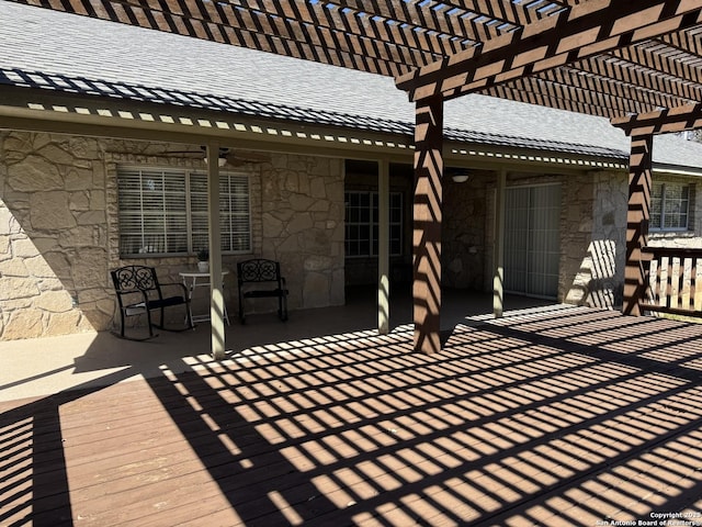 wooden terrace with a ceiling fan and a pergola