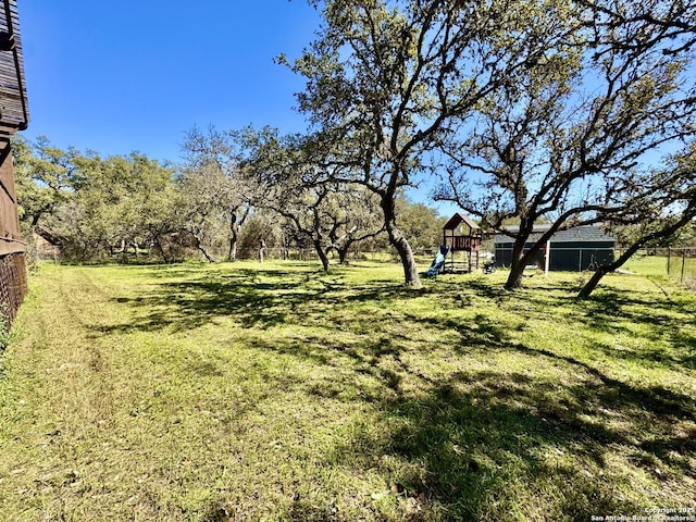 view of yard featuring fence and a playground