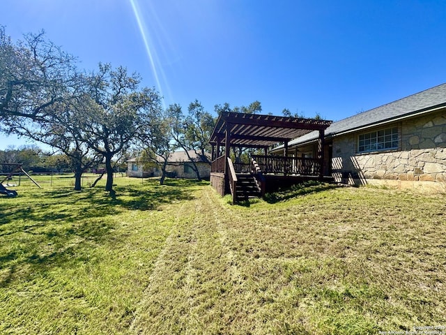 view of yard featuring a wooden deck, fence, and a pergola