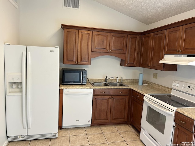 kitchen with white appliances, light tile patterned floors, visible vents, a sink, and under cabinet range hood