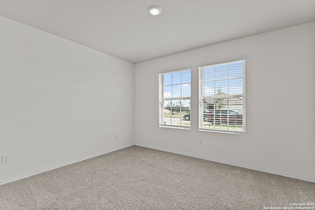 carpeted empty room with baseboards