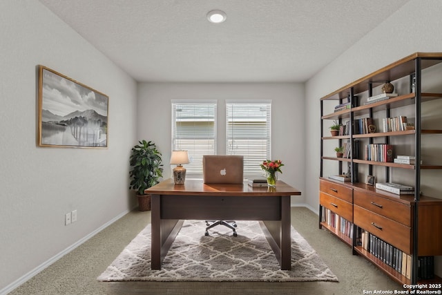 carpeted home office with a textured ceiling and baseboards