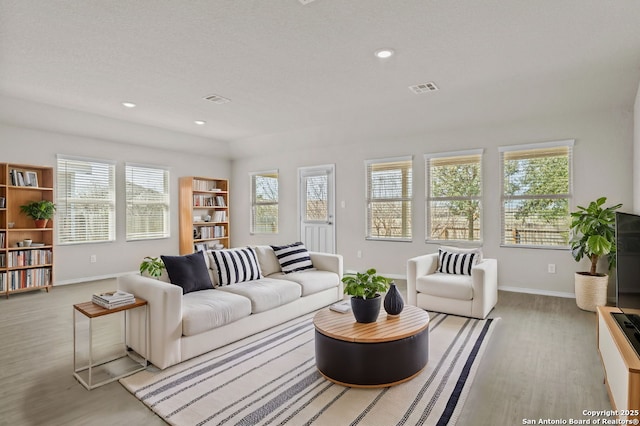 living area featuring visible vents, recessed lighting, baseboards, and wood finished floors