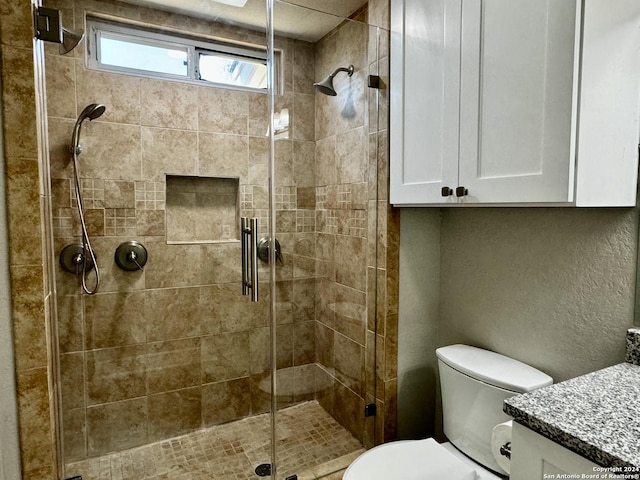 full bath with vanity, a shower stall, and toilet