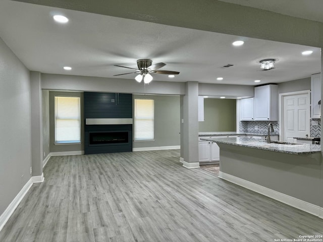 kitchen with visible vents, backsplash, white cabinetry, and a sink