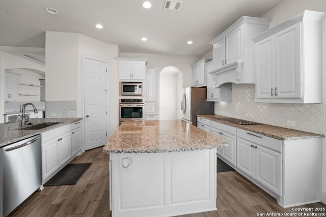 605 Albarella, Cibolo, TX 78108 - kitchen with appliances with stainless steel finishes, a sink, arched walkways, tasteful backsplash, and white cabinetry