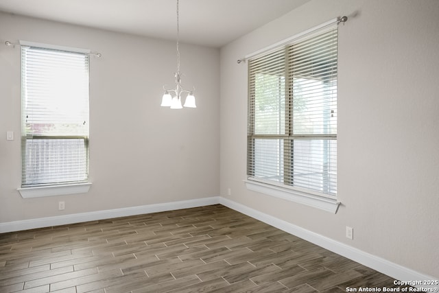 605 Albarella, Cibolo, TX 78108 - unfurnished room featuring wood finished floors, a chandelier, healthy amount of natural light, and baseboards