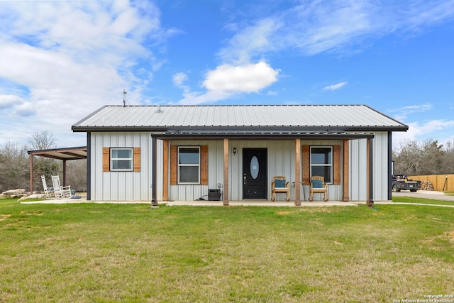 view of front facade featuring metal roof, board and batten siding, and a front yard