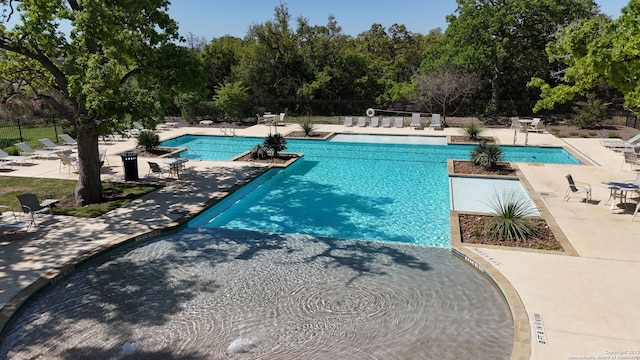 pool featuring fence and a patio