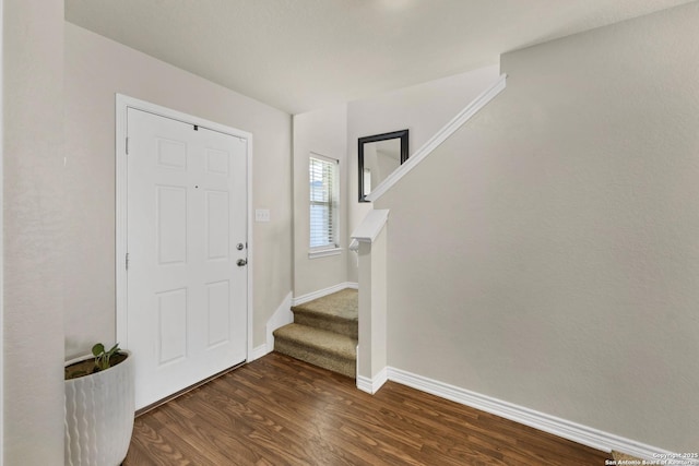 foyer entrance featuring stairway, baseboards, and wood finished floors