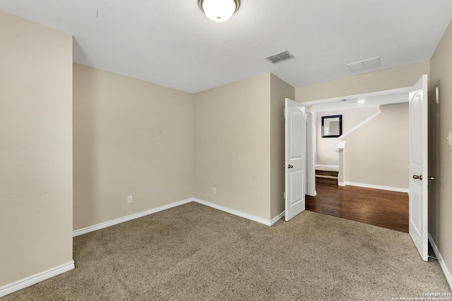 carpeted empty room with visible vents and baseboards