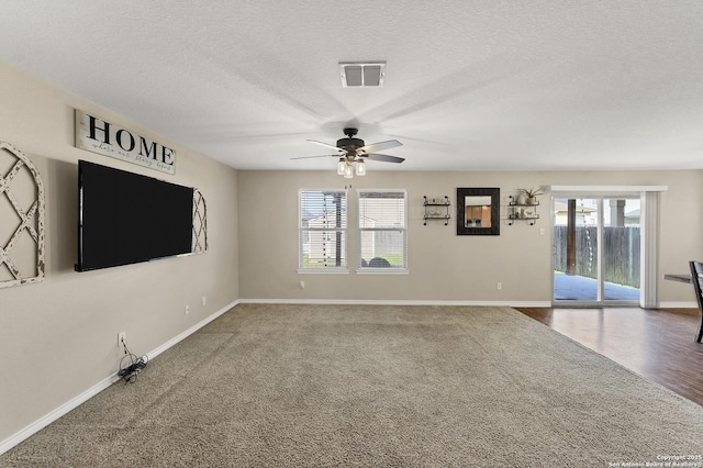 unfurnished living room with visible vents, baseboards, a textured ceiling, and a healthy amount of sunlight