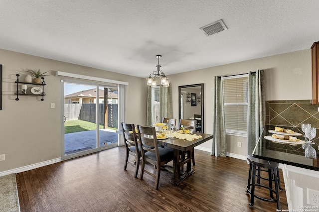 dining area with visible vents, baseboards, and dark wood finished floors