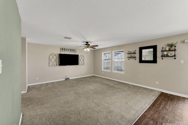 unfurnished living room with visible vents, a ceiling fan, a textured ceiling, wood finished floors, and baseboards