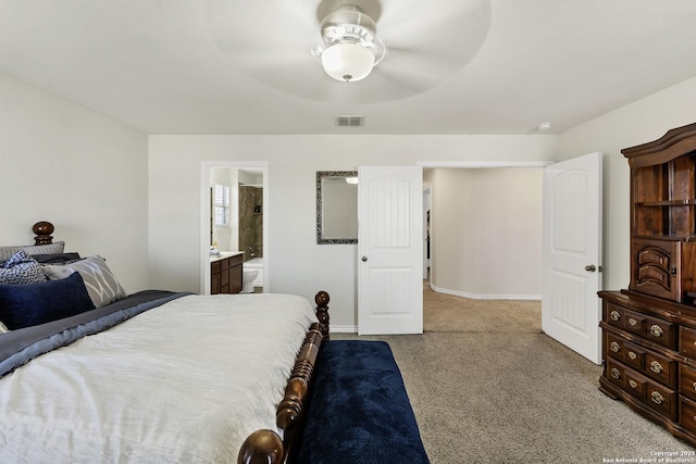 bedroom with visible vents, baseboards, light colored carpet, ensuite bath, and a ceiling fan