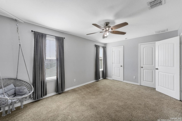 unfurnished bedroom featuring two closets, baseboards, visible vents, and carpet floors