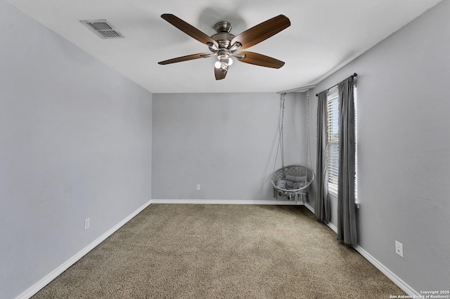 carpeted empty room featuring visible vents, baseboards, and ceiling fan