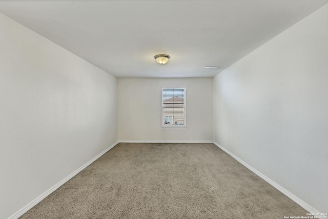 unfurnished room featuring baseboards and carpet