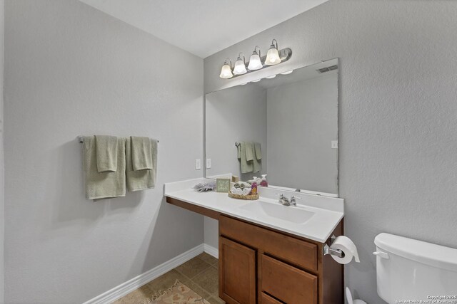 bathroom featuring tile patterned flooring, visible vents, baseboards, toilet, and vanity