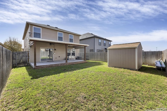 rear view of property with an outbuilding, a storage unit, and a fenced backyard