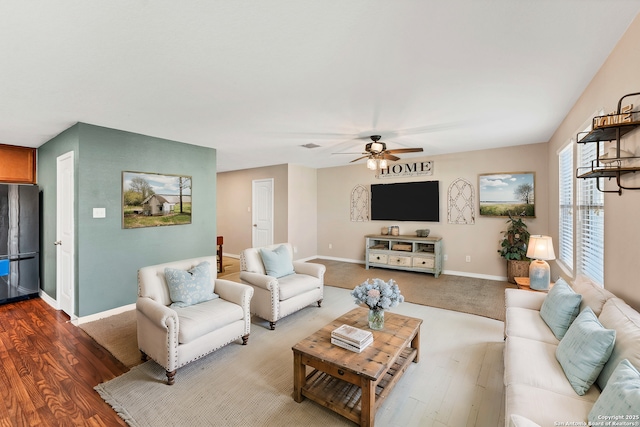 living area with wood finished floors, baseboards, and ceiling fan