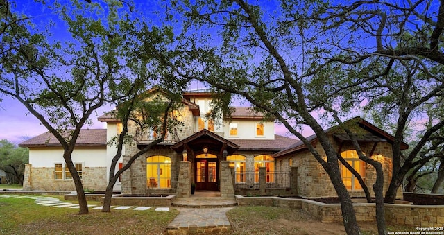 mediterranean / spanish home featuring stone siding and stucco siding