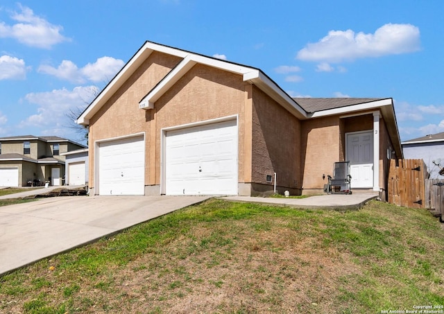 ranch-style home with concrete driveway, fence, a front lawn, and stucco siding