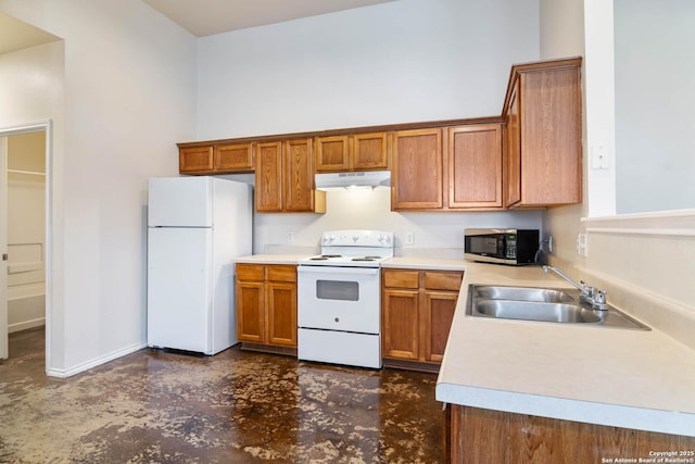 kitchen featuring under cabinet range hood, light countertops, brown cabinetry, white appliances, and a sink