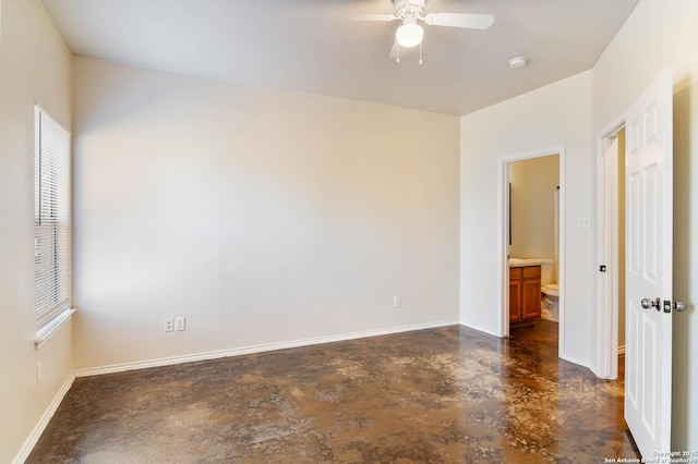 unfurnished room featuring a ceiling fan, finished concrete flooring, and baseboards