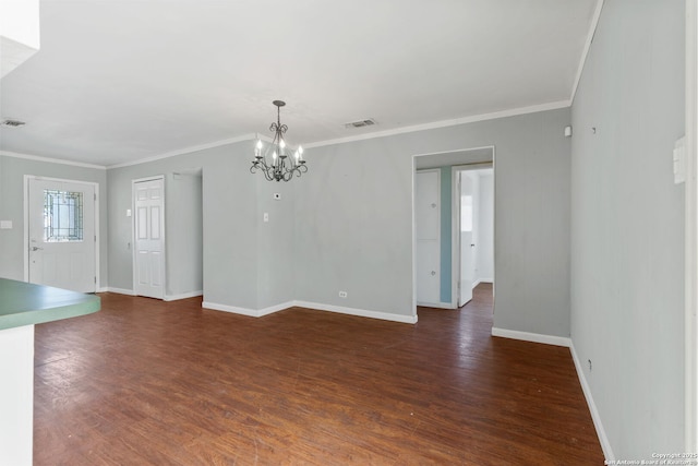 unfurnished dining area with dark wood finished floors, visible vents, crown molding, and a chandelier