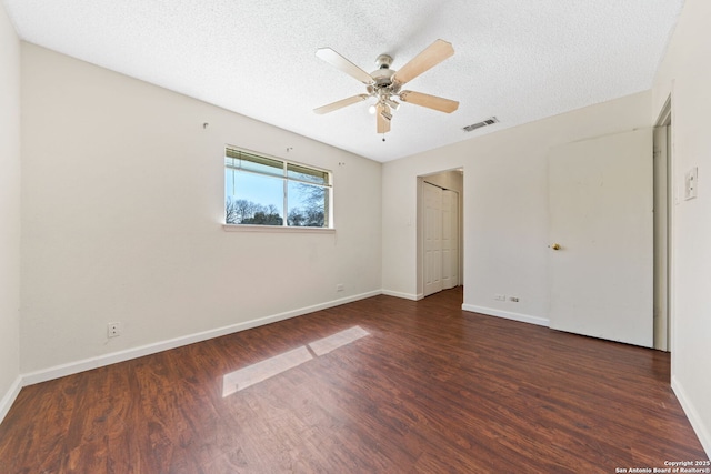 unfurnished bedroom featuring visible vents, a textured ceiling, baseboards, and wood finished floors