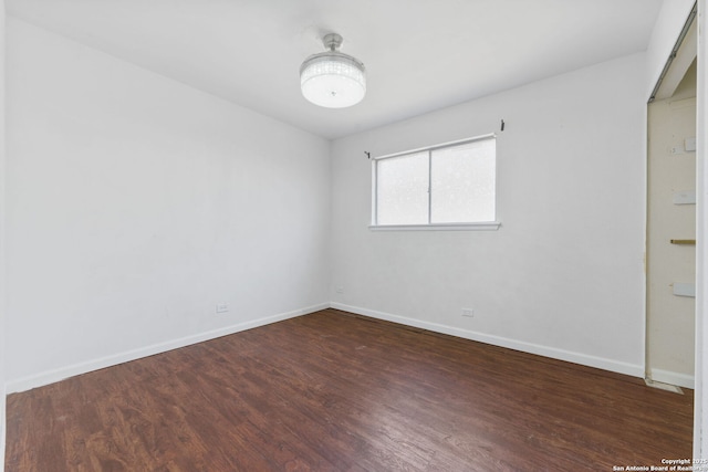 empty room with baseboards and wood finished floors