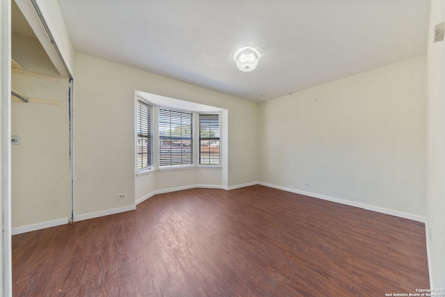 empty room featuring baseboards and wood finished floors