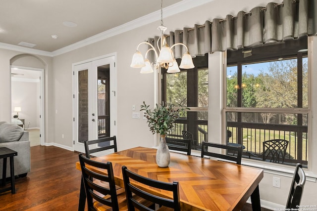 dining area featuring dark wood-style floors, french doors, crown molding, and arched walkways